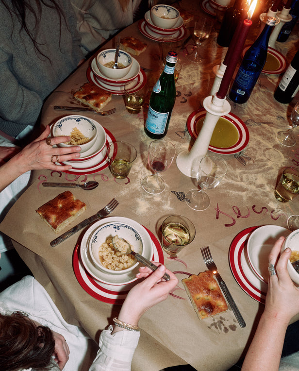 table with plates and bowls of soup with hands