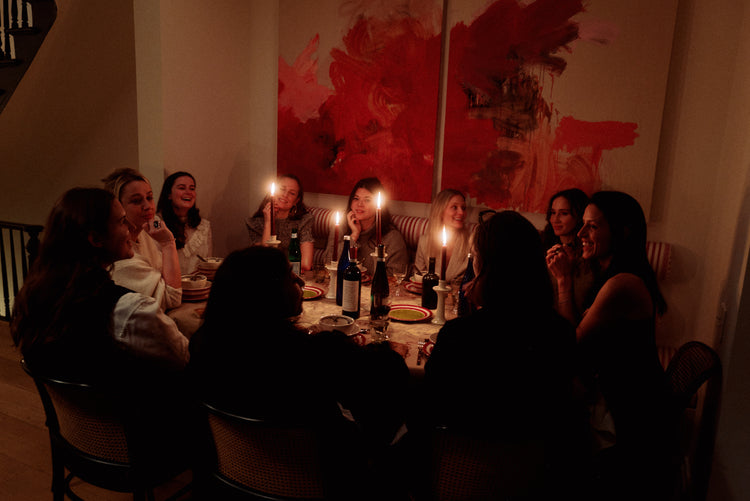 table with woman talking over dinner and candle light 