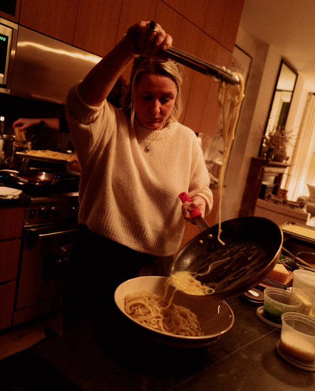 woman plating pasta from a pan