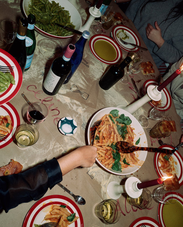 table with bowls of pasta and hands