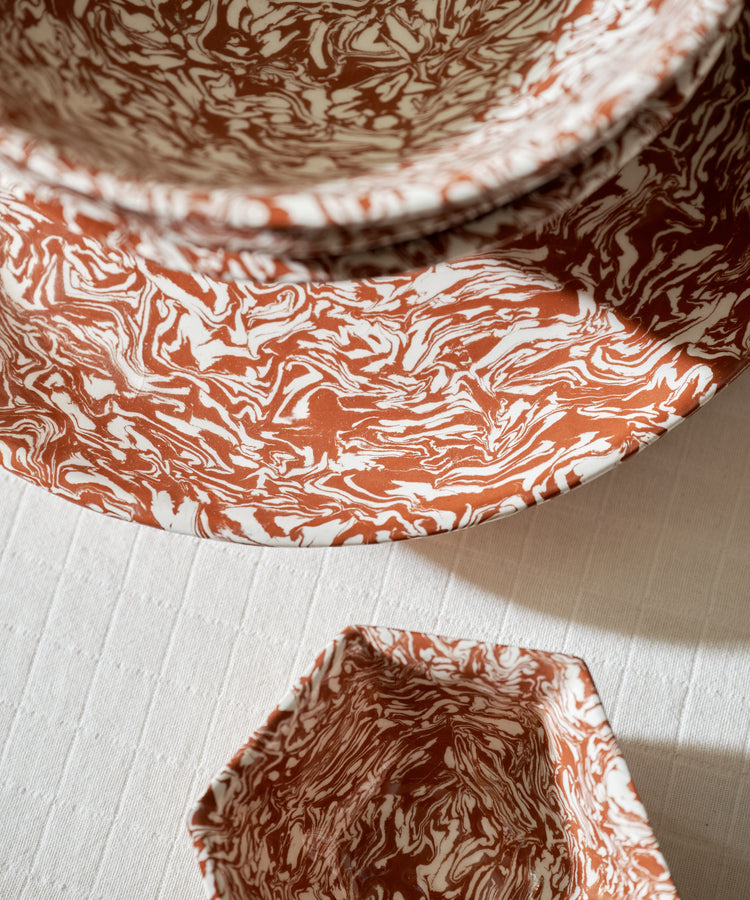 Three Celine Serving Platters, each handcrafted with red and white Aptware marbled patterns, are arranged on a textured white surface and viewed from above.