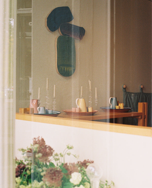 through the window wall of art and shelves in a shop