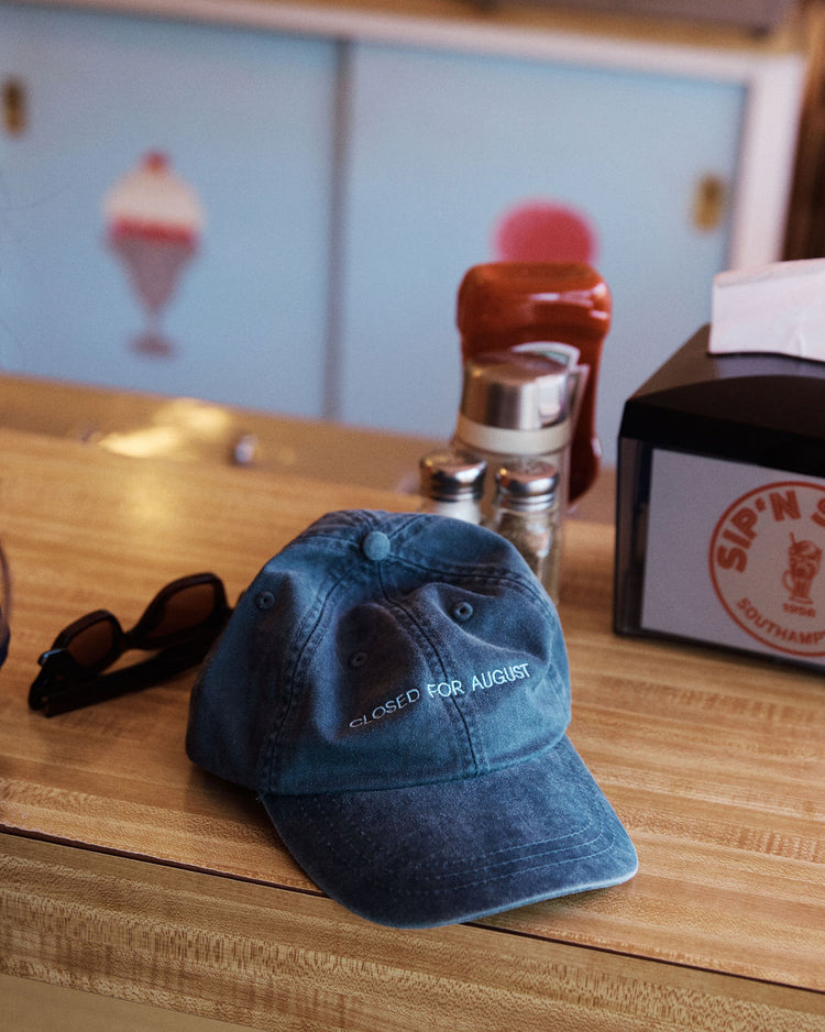 The Closed for August Cap—a blue European out-of-office hat embroidered with 