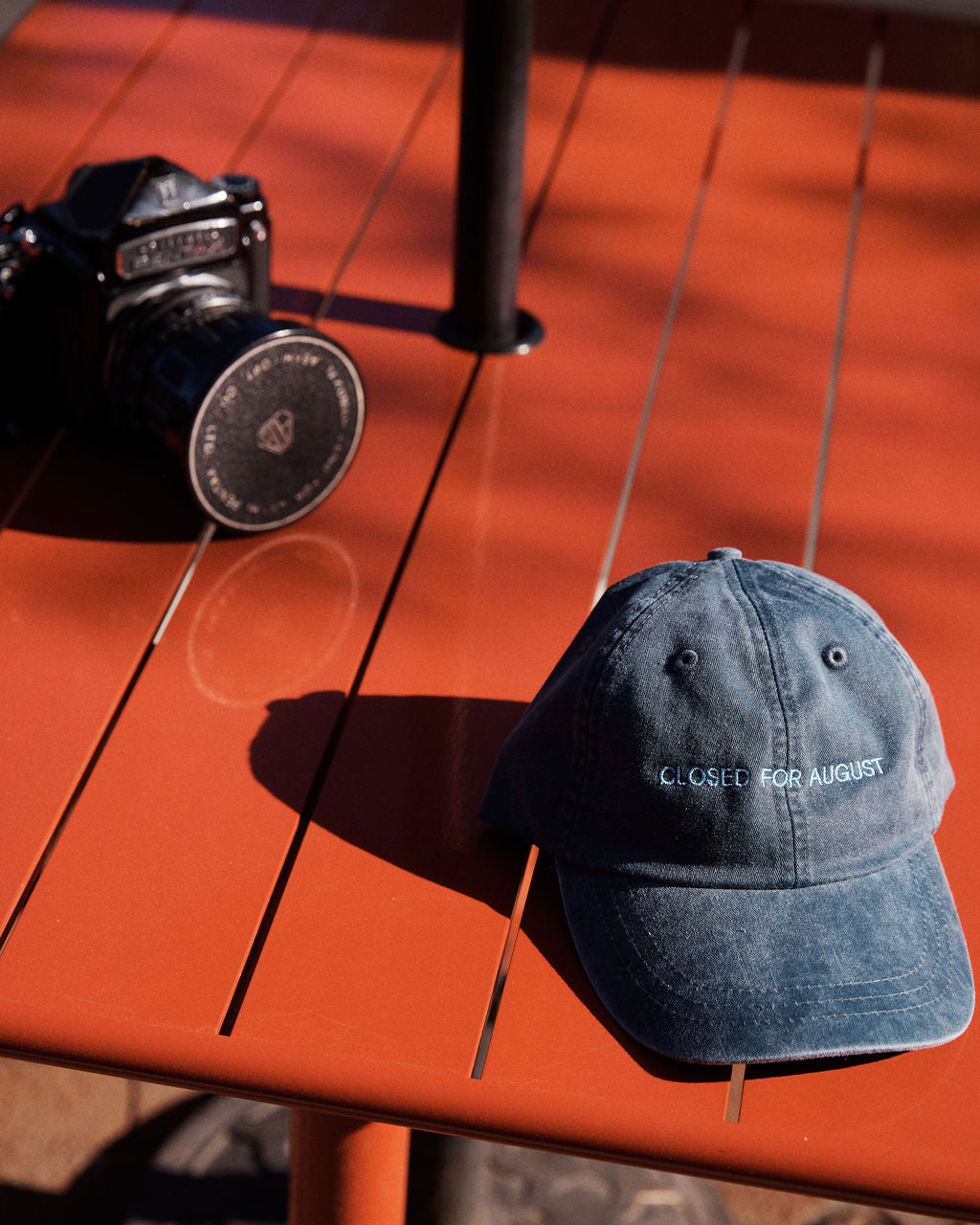 The Closed for August Cap—a blue cap with 