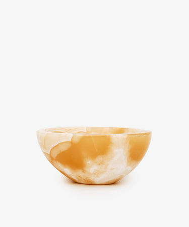 An alabaster catchall bowl of white and deep yellow coloring, ideal for organizing small objects.