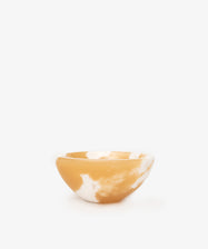 An alabaster catchall bowl of white and deep yellow coloring, ideal for organizing small objects.