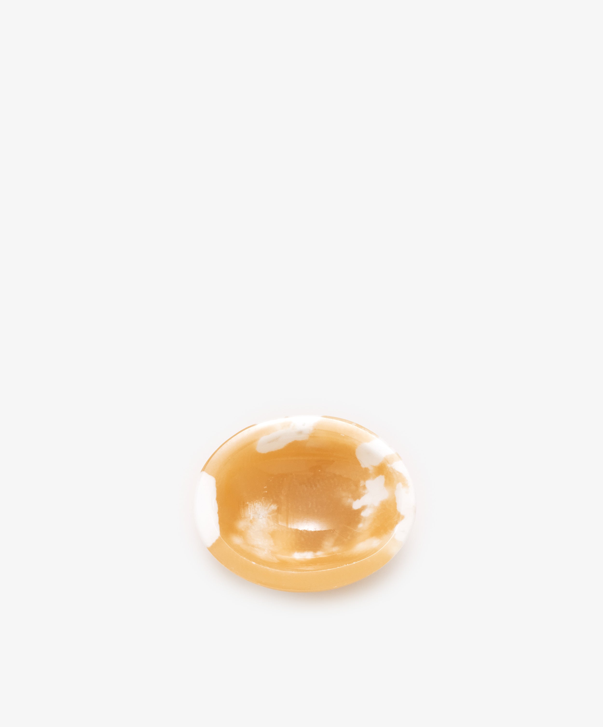 An alabaster catchall bowl of white and deep yellow coloring, ideal for organizing small objects.
