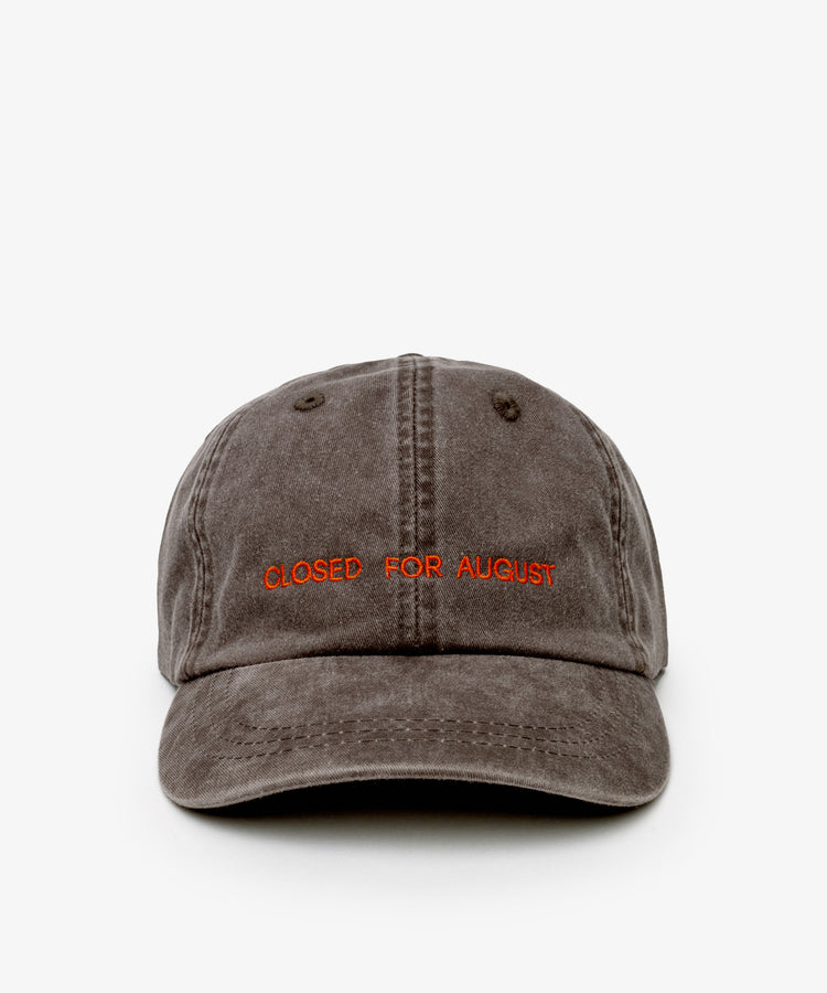 The Closed for August Cap—a gray baseball cap featuring “CLOSED FOR AUGUST” embroidered in orange—blends essential European out-of-office style with sun protection.