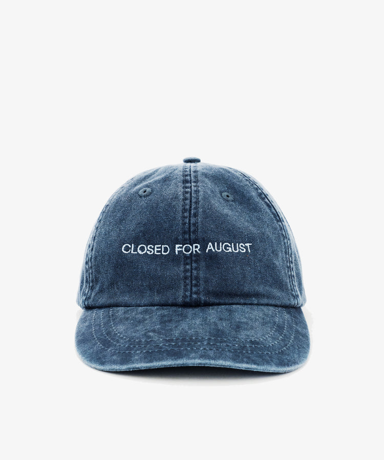 The Closed for August Cap is a blue denim baseball cap with white embroidered 