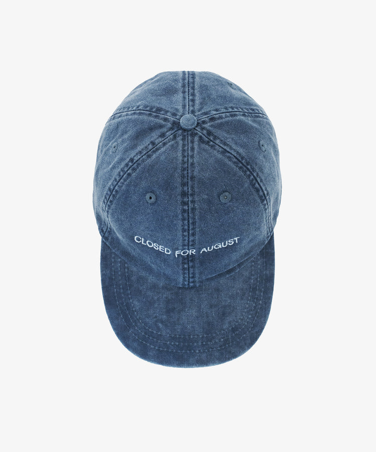 The Closed for August Cap is a blue denim hat with visible stitching and 