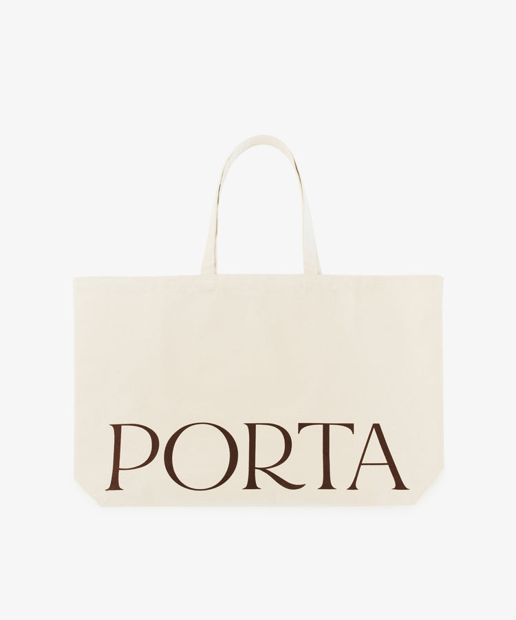 The PORTA Canvas Tote Bag is a spacious cream-colored tote with two handles and bold black 