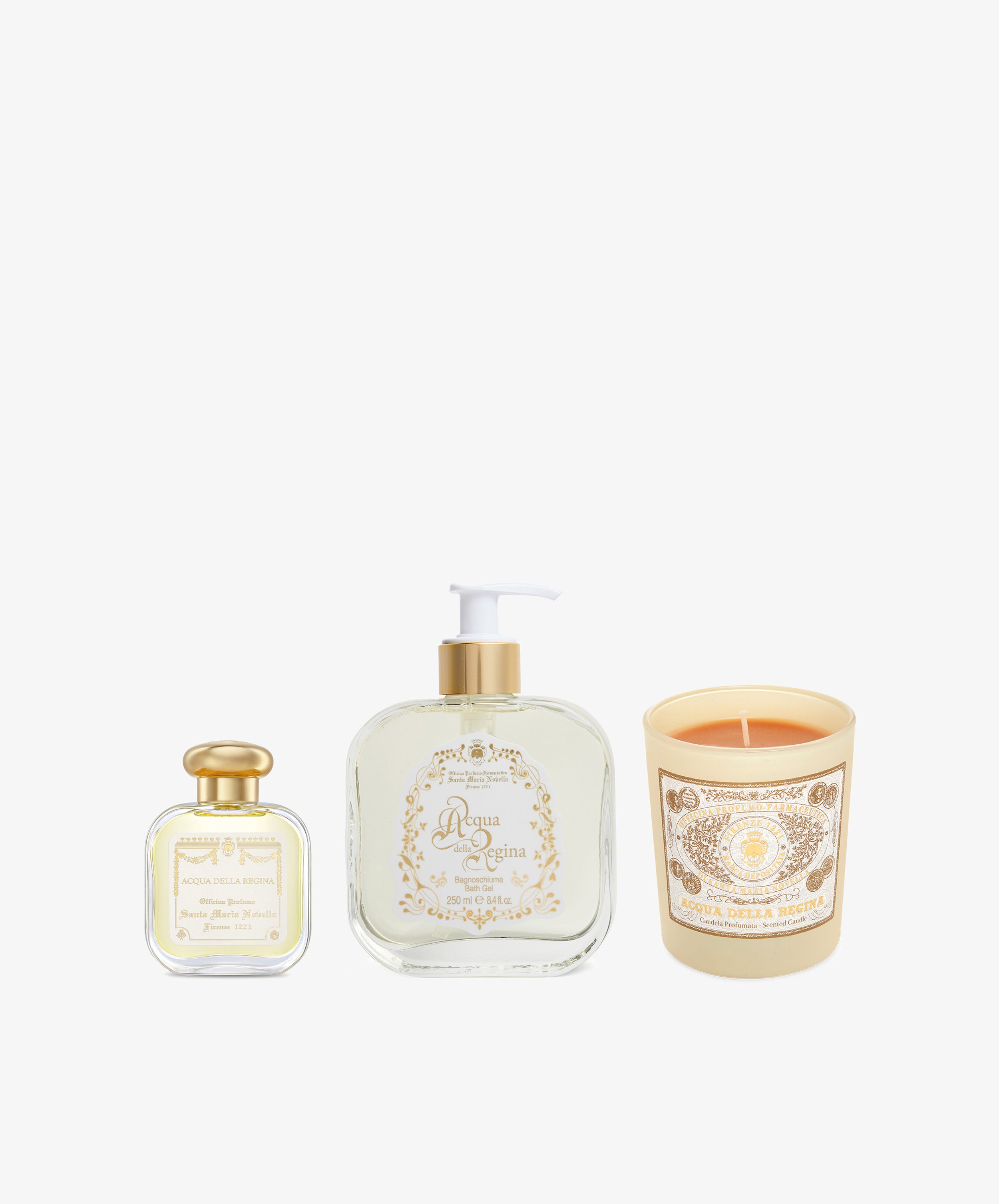 The Acqua Della Regina Bundle—three items with cream and gold labels, including a perfume bottle, liquid soap dispenser, and scented candle—are arranged on a white background, evoking the citrus brightness of this Florentine fragrance.