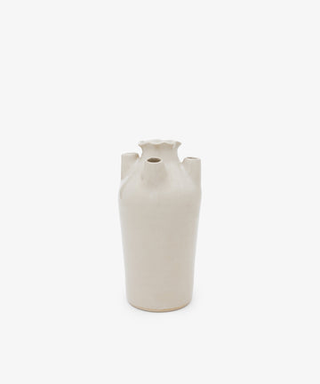 The Four Spouted Tulipere is a beige ceramic vase featuring a narrow base, fluted top, and four protruding spouts, echoing modern tulipiere design, displayed against a plain white background.