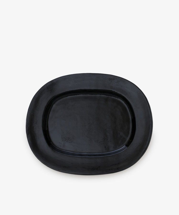 A large rectangular platter, crafted from ceramic and finished in black, is centered on a plain white background, showcasing the modern elegance of a contemporary serving piece.