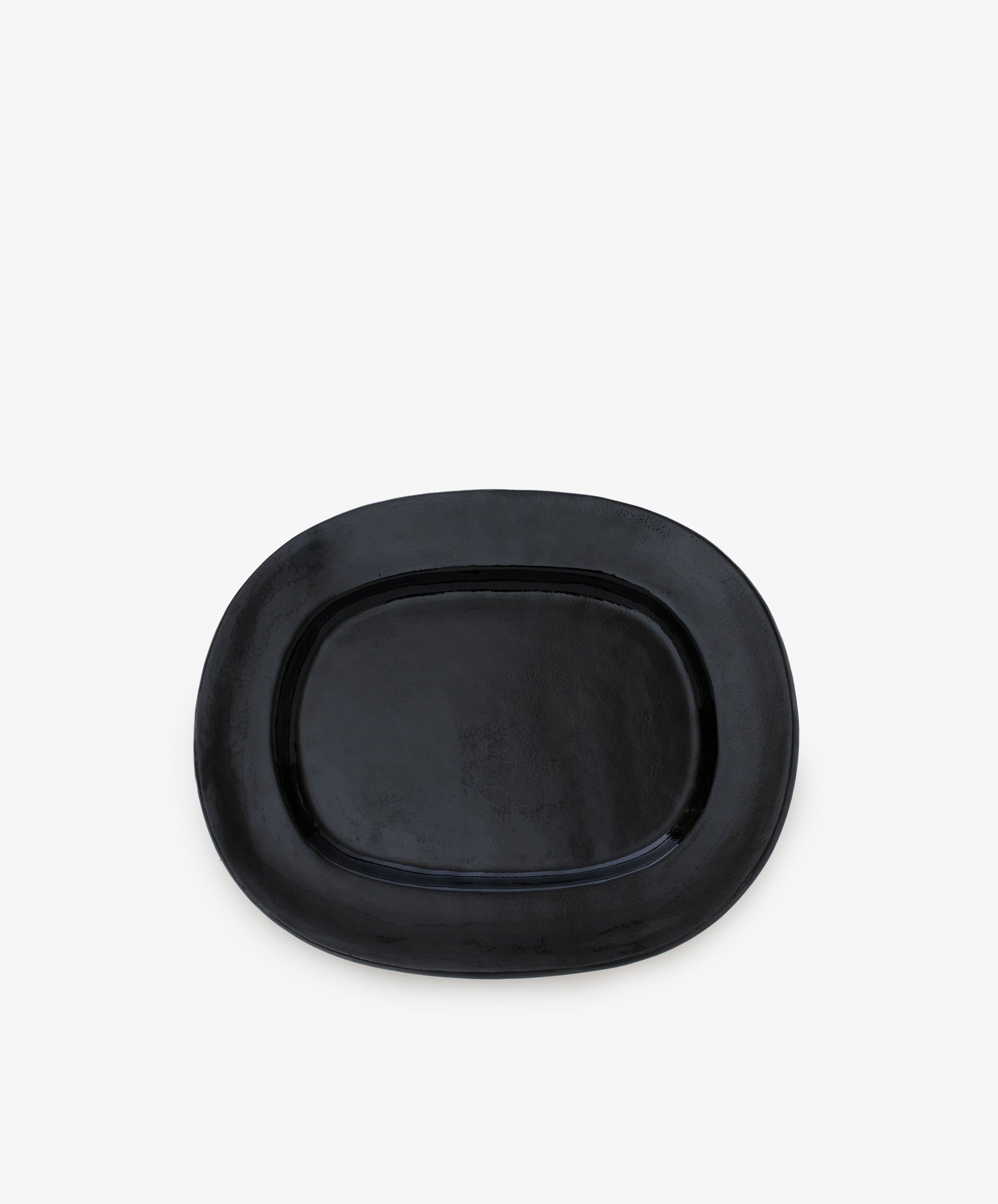 A small, black, rectangular ceramic serving platter with a glossy finish is displayed against a plain white background, adding a touch of modern tableware elegance.