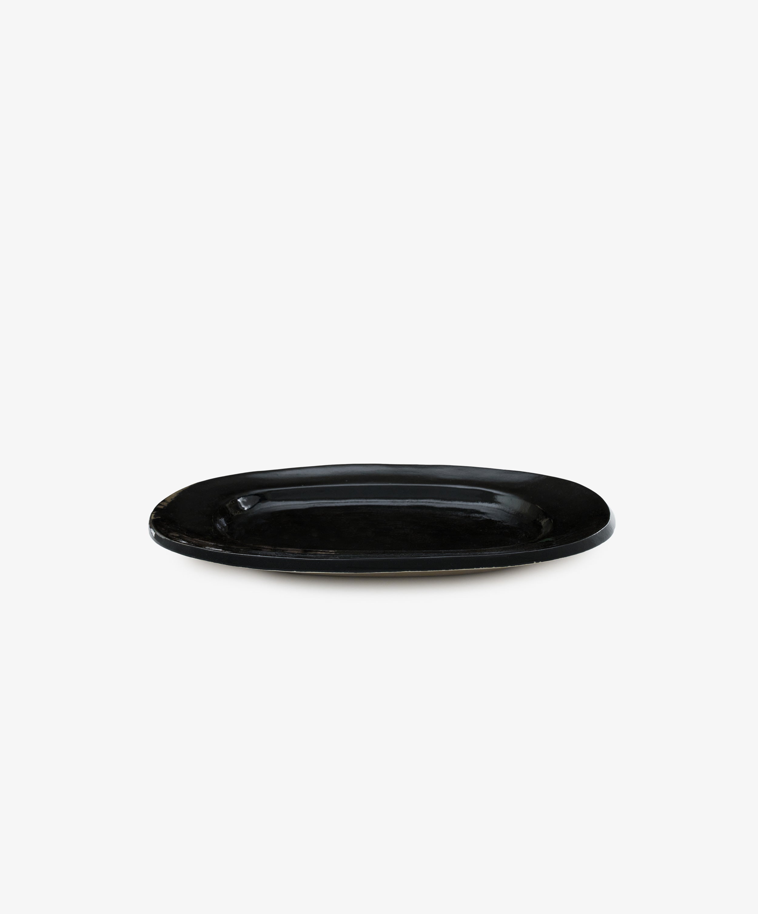 A Small Rectangular Platter in black ceramic is displayed against a plain white background, highlighting the modern elegance of contemporary tableware.
