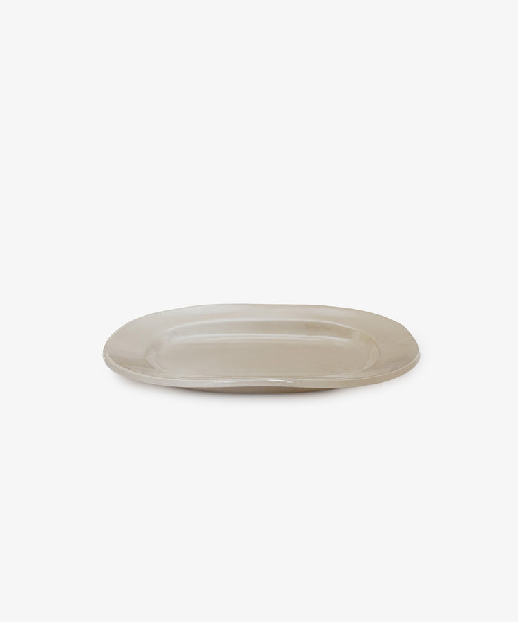 The Small Rectangular Platter is an off-white ceramic piece with a matte surface, ideal for everyday use. Its plain, rectangular shape is shown against a white background.