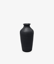 The Wheel Thrown Vase is a tall, matte black sculptural piece with a narrow neck and wide body, set against a plain white background.