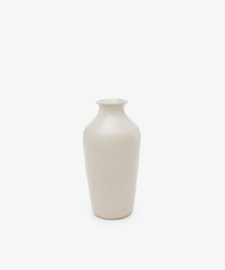 The Wheel Thrown Vase is a tall, off-white vase with a narrow neck and rounded shoulders, inspired by Delftware, shown on a white background.