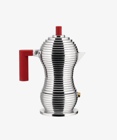 The Pulcina Espresso Coffee Maker, designed by Michele de Lucchi with a ribbed hourglass metal body and vivid red handle and knob, is displayed against a plain white background.