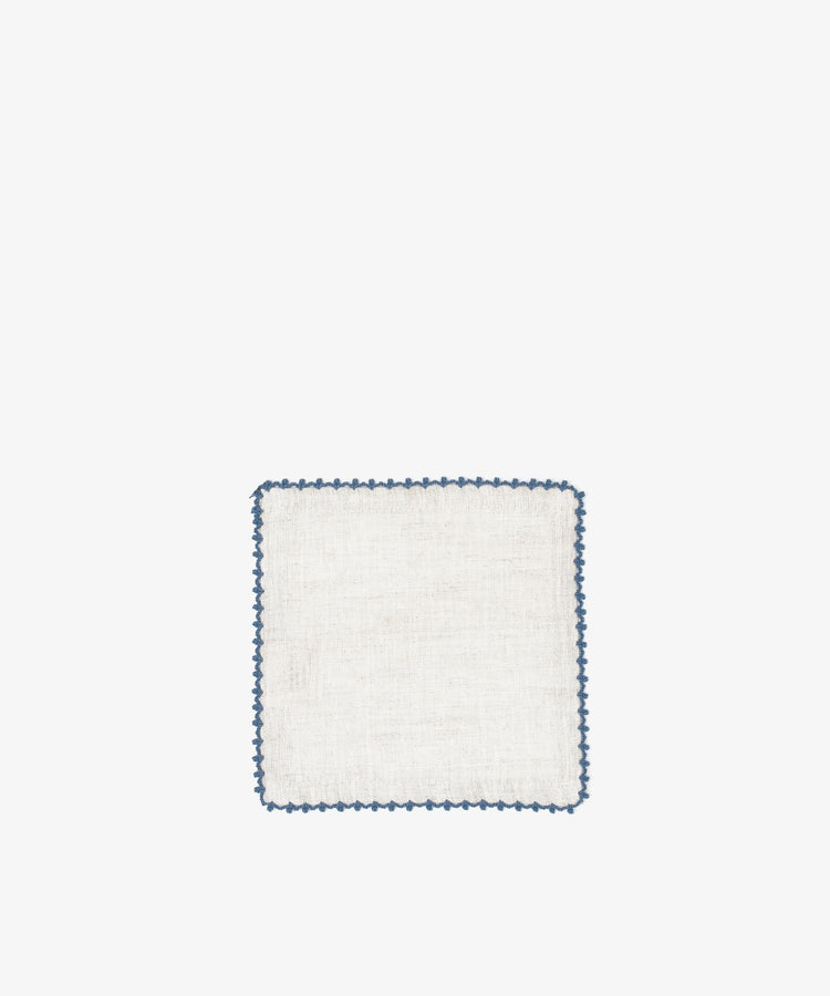 The Nico Cocktail Napkin, Set of 4, features white linen with a blue scalloped edge, hand-finished and showcased on a plain white background.