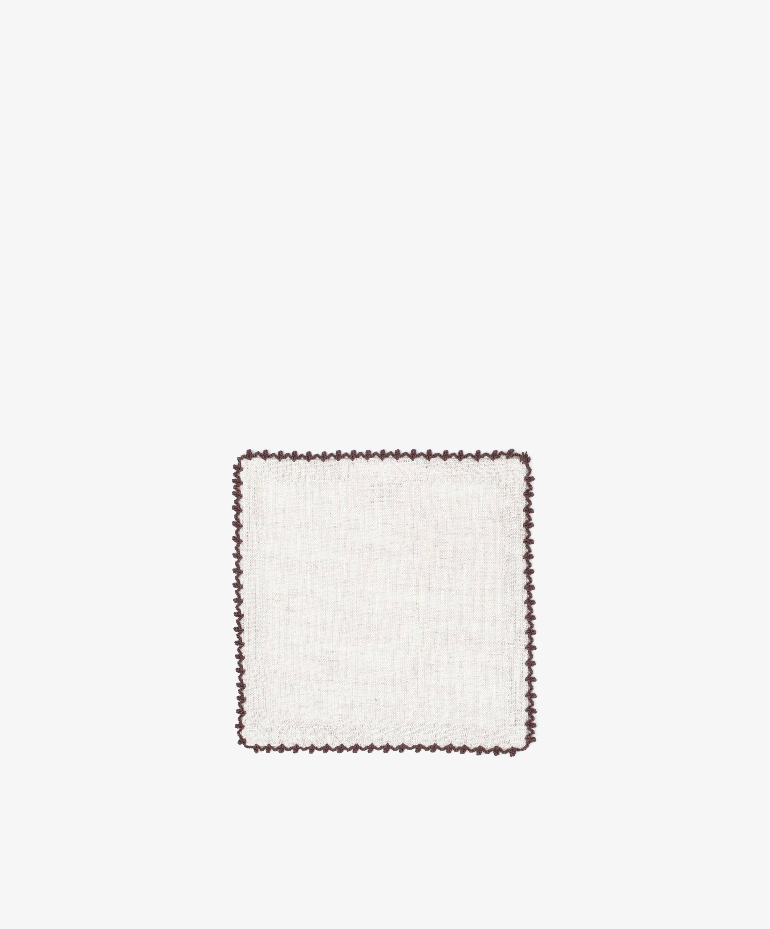 The Nico Cocktail Napkin, Set of 4, features hand-finished square white linen from Portugal with a dark scalloped border, set against a plain white background.