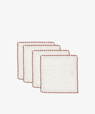 The Nico Cocktail Napkin, Set of 4 features white linen napkins with red stitched borders, hand-finished in Portugal, neatly stacked against a plain white background.