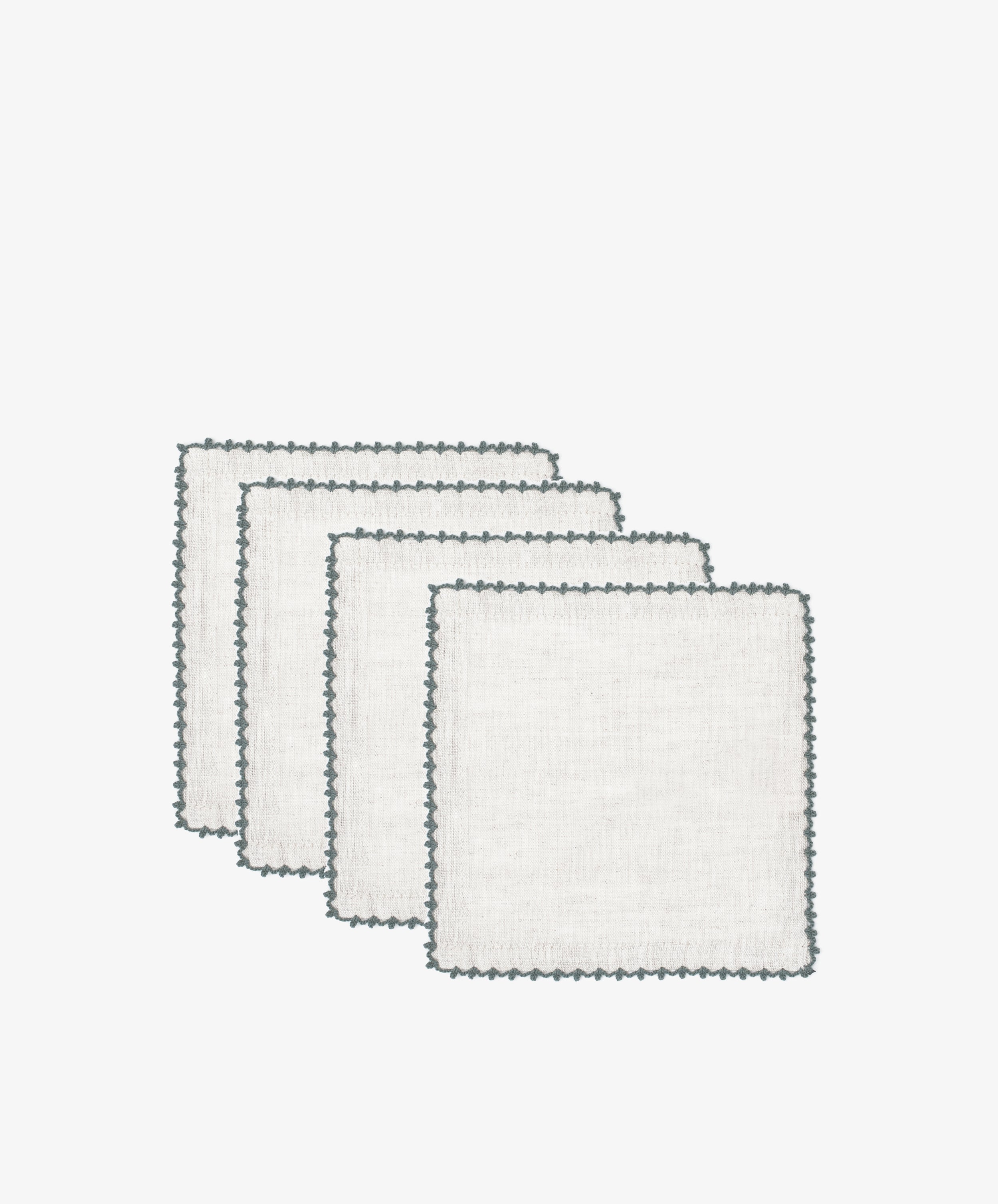 Four white Nico Cocktail Napkins with dark scalloped edges, arranged in a staggered stack against a plain white background.