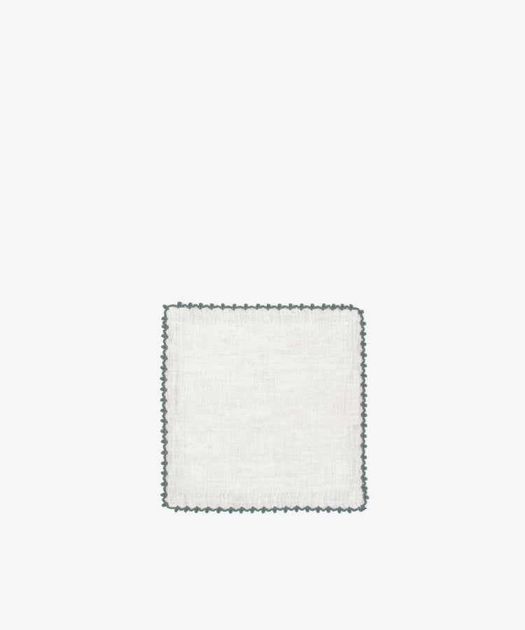 The Nico Cocktail Napkin, Set of 4 features square white linen napkins with a decorative dark scalloped edge, displayed on a plain white background.