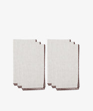 Six folded beige Nico Napkins with brown contrast stitching, arranged in two overlapping stacks on a white background—perfect modern table linens for any setting.
