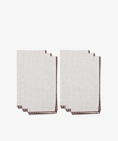 Six folded beige Nico Napkins with brown contrast stitching, arranged in two overlapping stacks on a white background—perfect modern table linens for any setting.