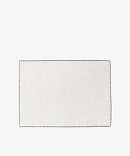 The Nico Placemat, Set of 6, features rectangular light beige linen mats with hand-stitched edges and dark borders—ideal for adding elegance to your table.