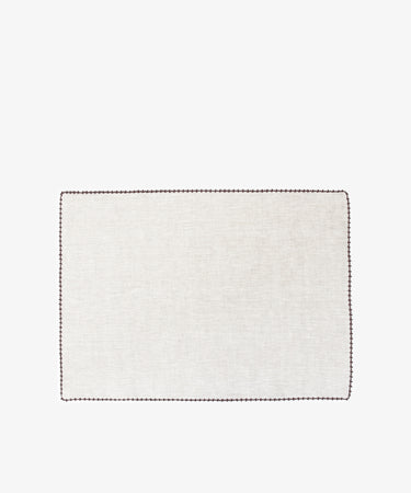 The Nico Placemat, Set of 6, features rectangular light beige linen mats with hand-stitched edges and dark borders—ideal for adding elegance to your table.