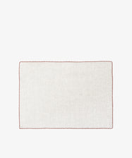 The Nico Placemat, Set of 6, features rectangular, light linen mats with elegant red hand-stitched edges—ideal for bringing refined style to any table setting.