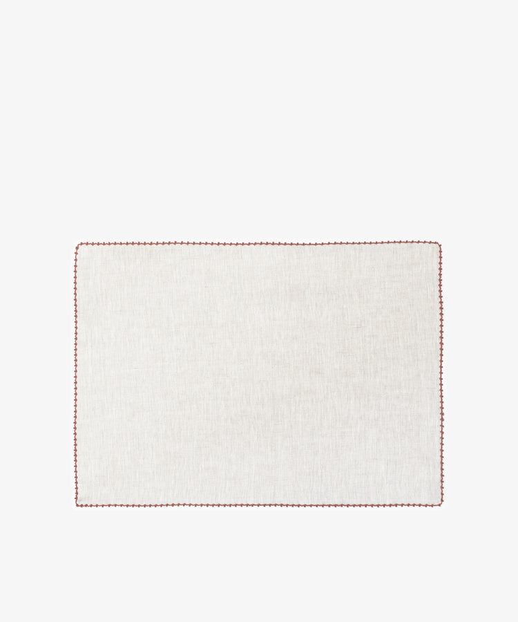 The Nico Placemat, Set of 6, features rectangular, light linen mats with elegant red hand-stitched edges—ideal for bringing refined style to any table setting.