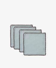 A set of four Nico Cocktail Napkins, each in light blue with dark scalloped edges and a subtle espresso contrast stitch, arranged in a staggered stack on a white background.