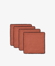 Set against a plain white background, the Nico Cocktail Napkin, Set of 4 features rust-colored linen napkins with black scalloped trim and subtle espresso contrast stitching, arranged in a staggered stack. Each hand-finished napkin brings an elegant touch to any table setting.