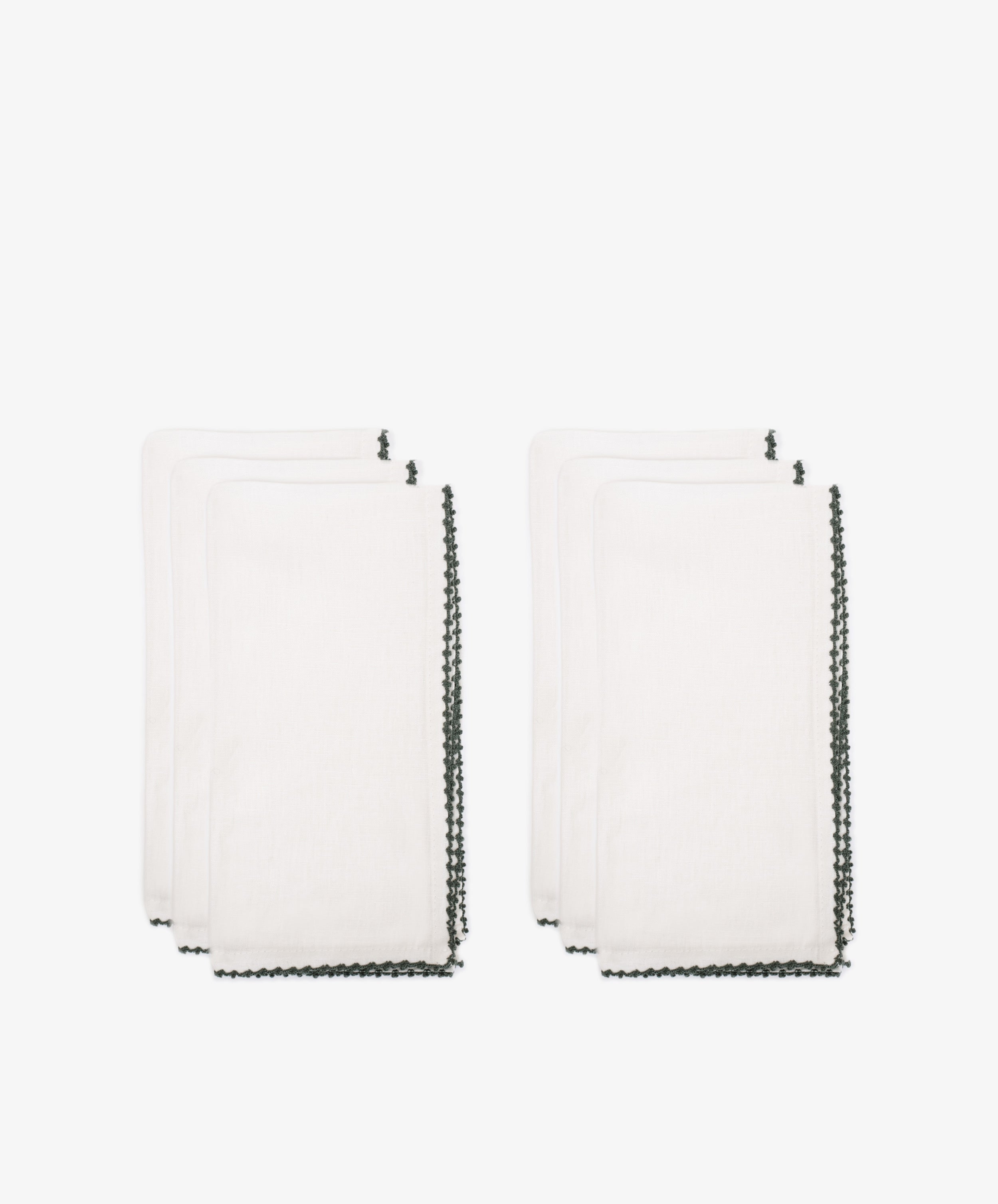 The Nico Napkin Set of 6 features white cloth napkins with dark, decorative edges, displayed against a plain white backgroundâ€”ideal for enhancing any table setting.