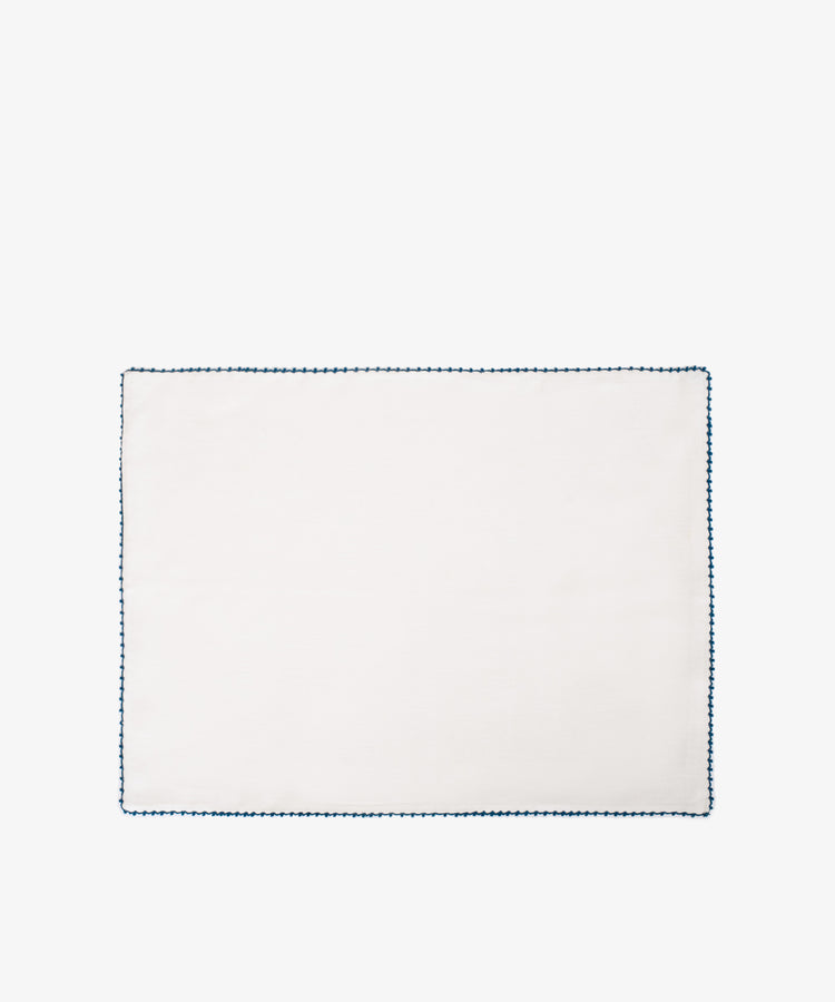 The Nico Placemat, Set of 6, features rectangular white linen with a blue hand-stitched edgeâ€”ideal for adding elegant decor to your table. Displayed on a plain white background.
