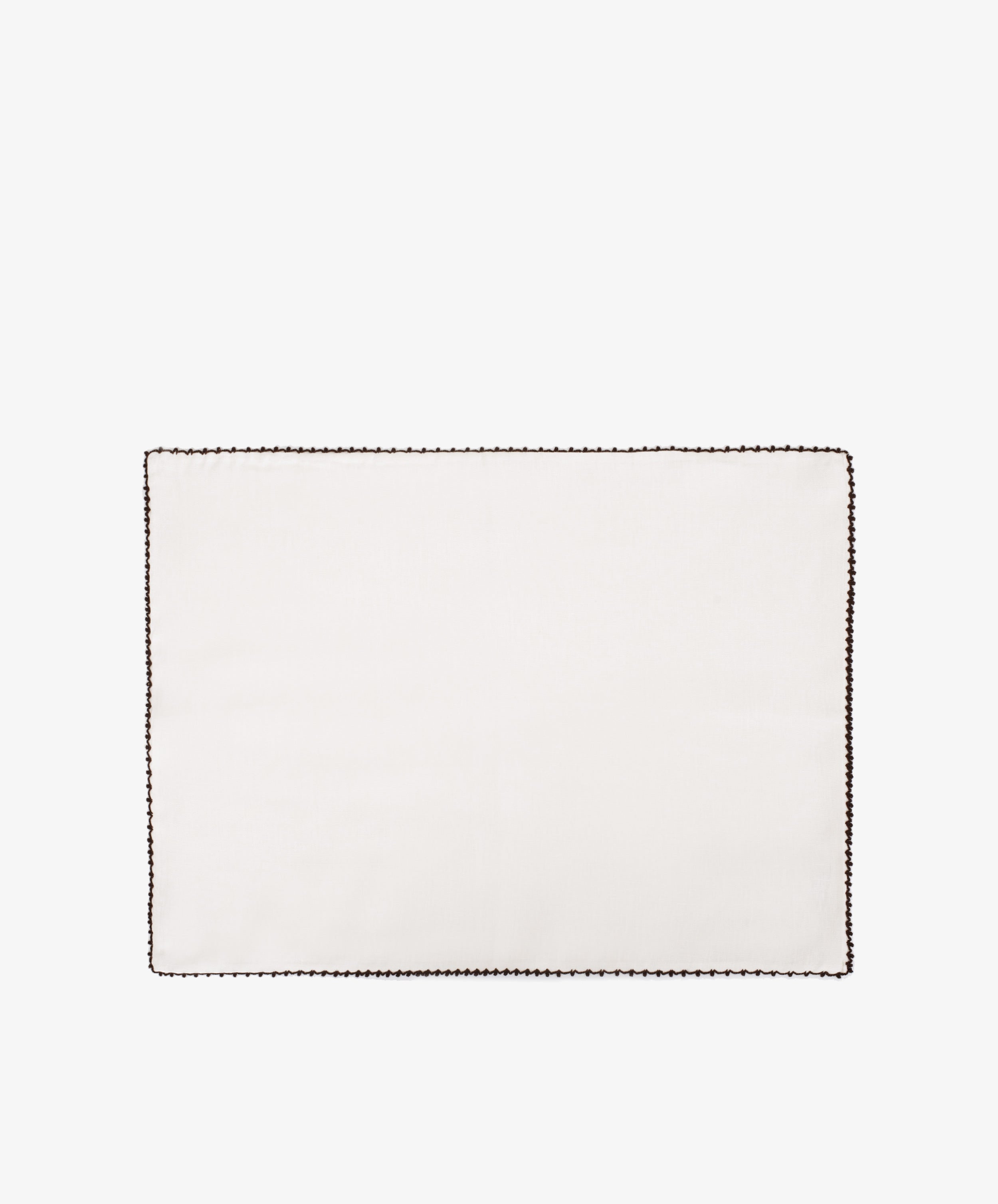 The Nico Placemat, Set of 6, features rectangular white linen with a dark hand-stitched edge, displayed on a plain white backgroundâ€”ideal for bringing Italian elegance to your table.