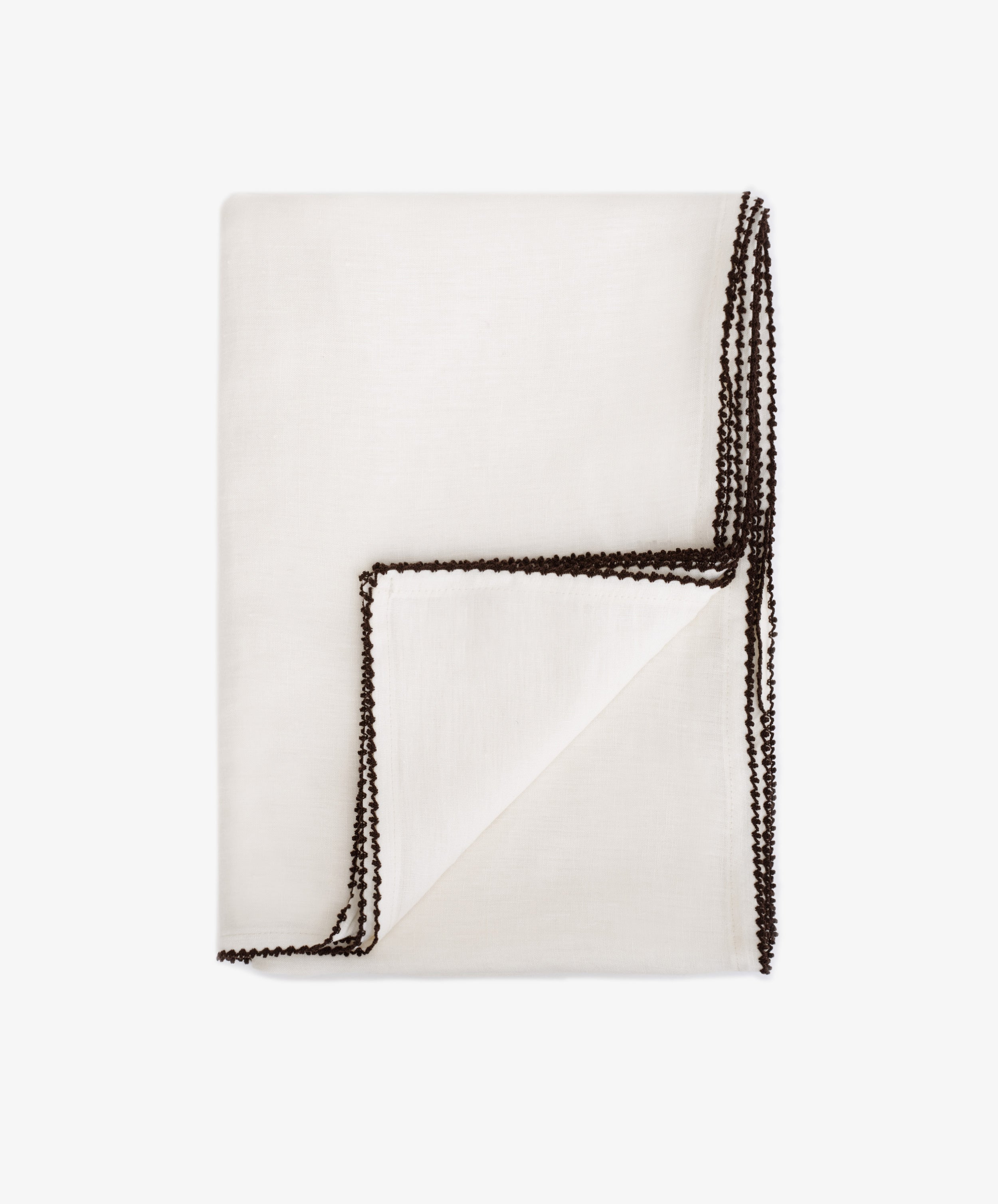 The Nico Tablecloth is a white linen tablecloth with dark contrast stitching along the edges, shown against a plain white backgroundâ€”an elegant choice for table decor.