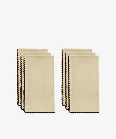 Four folded beige hand-finished napkins with dark espresso contrast stitch along the edges, arranged in two groups of two, on a white background.