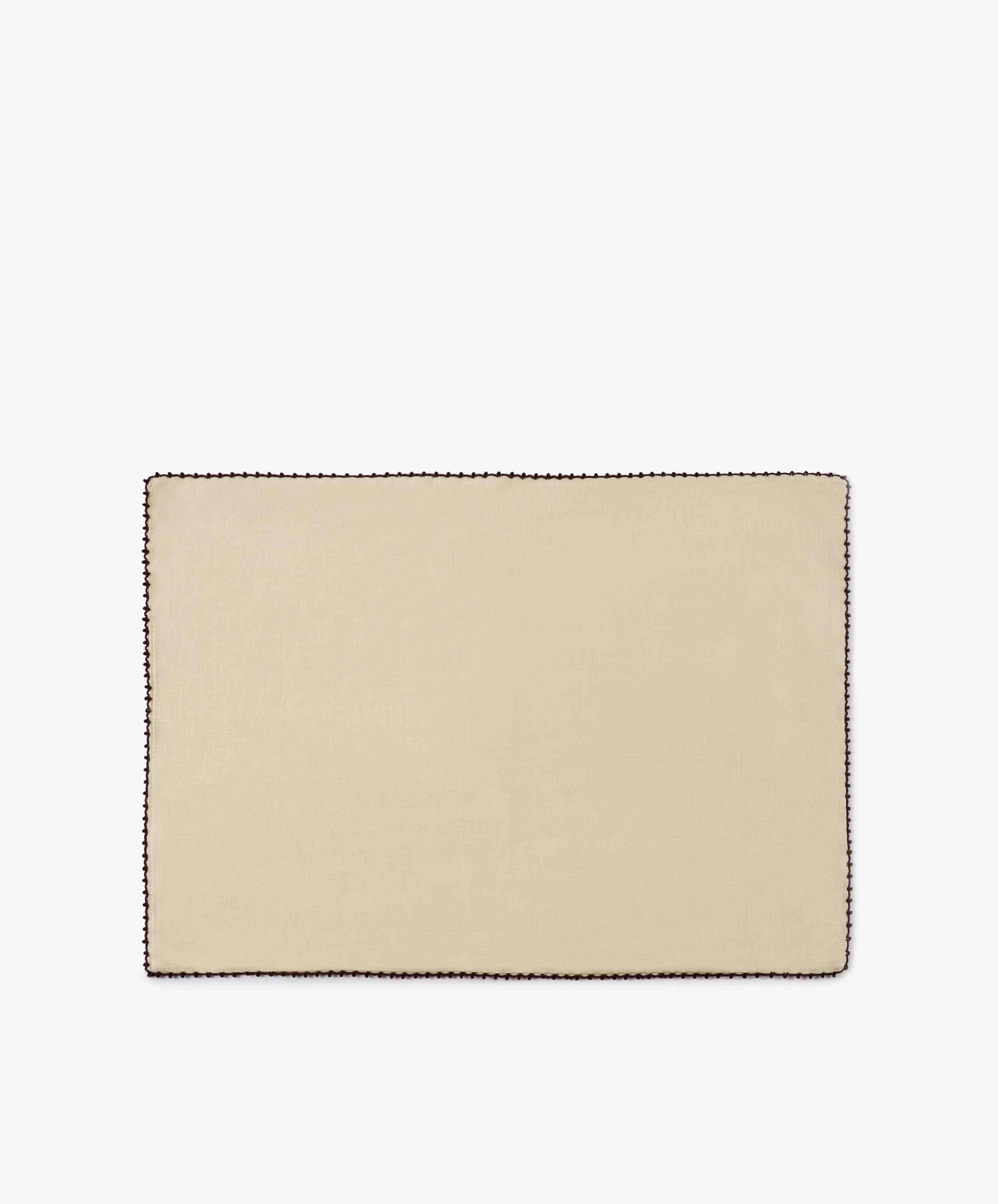The Nico Placemat, Set of 6 features a rectangular design in beige linen with an espresso stitch border in a contrasting dark color, hand finished for a refined touch, and displayed on a plain white background.