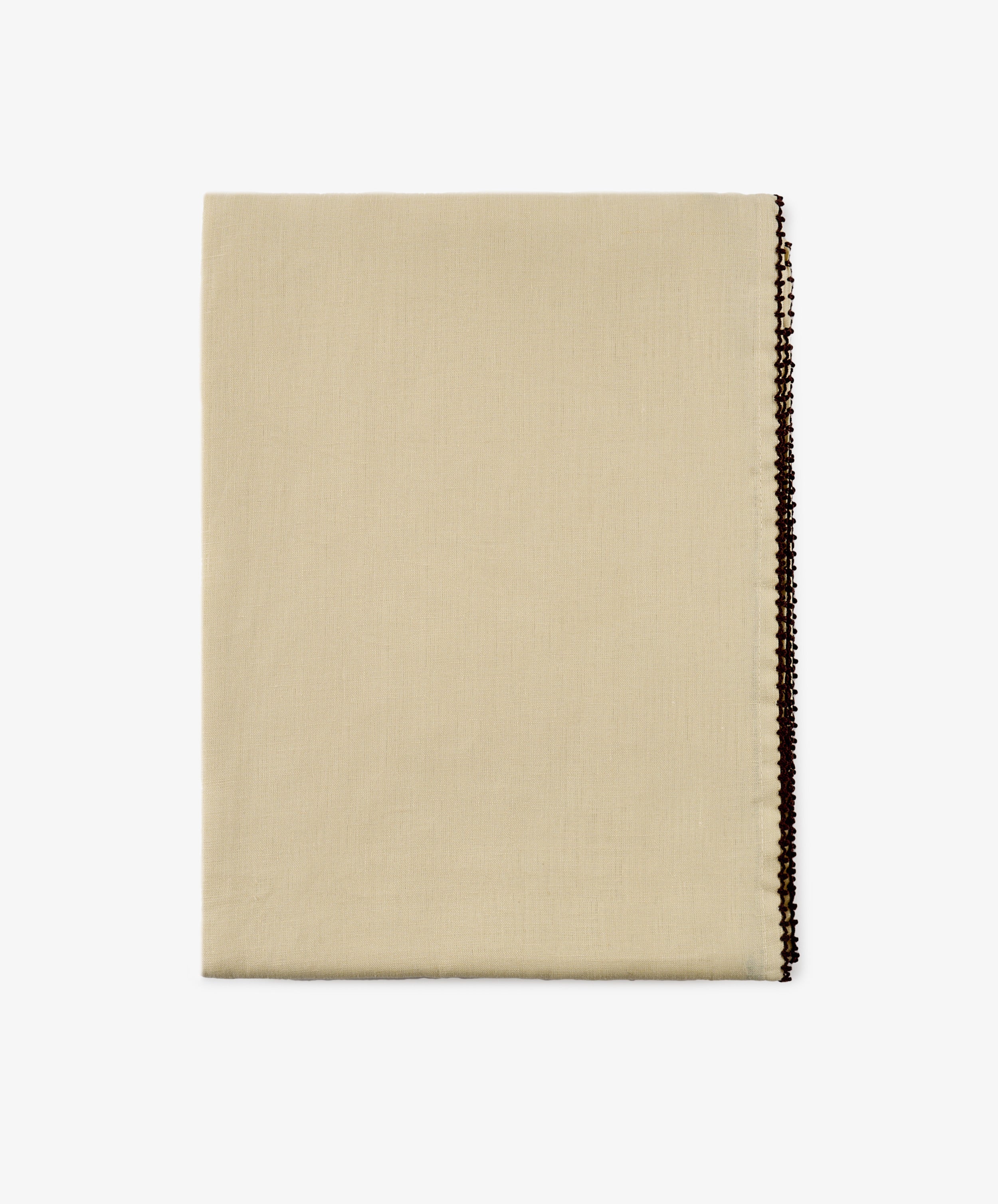 The Nico Tablecloth, a folded beige fabric with a decorative dark edge, is displayed on a white background.