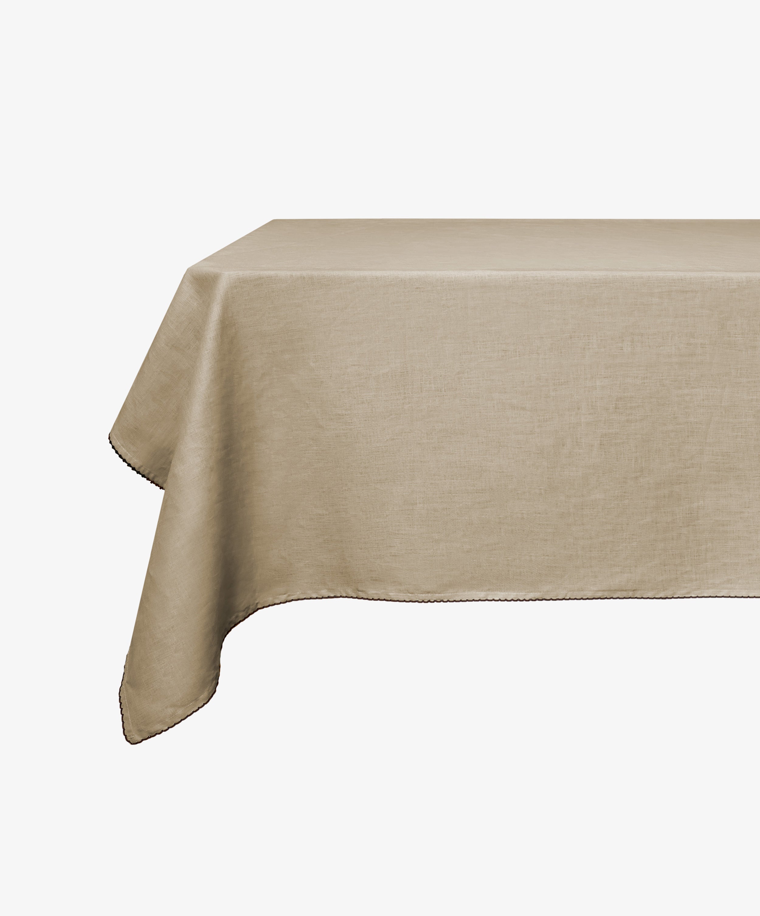 The Nico Tablecloth, in hand-finished linen and antique yellow, is draped over a table against a plain white background.