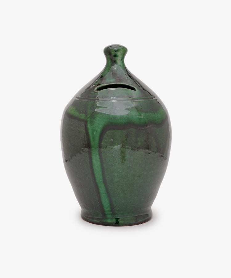The Hugo Money Pot, a green ceramic money bank with a lid, glossy finish, and subtle marbled pattern, is displayed against a plain white background.