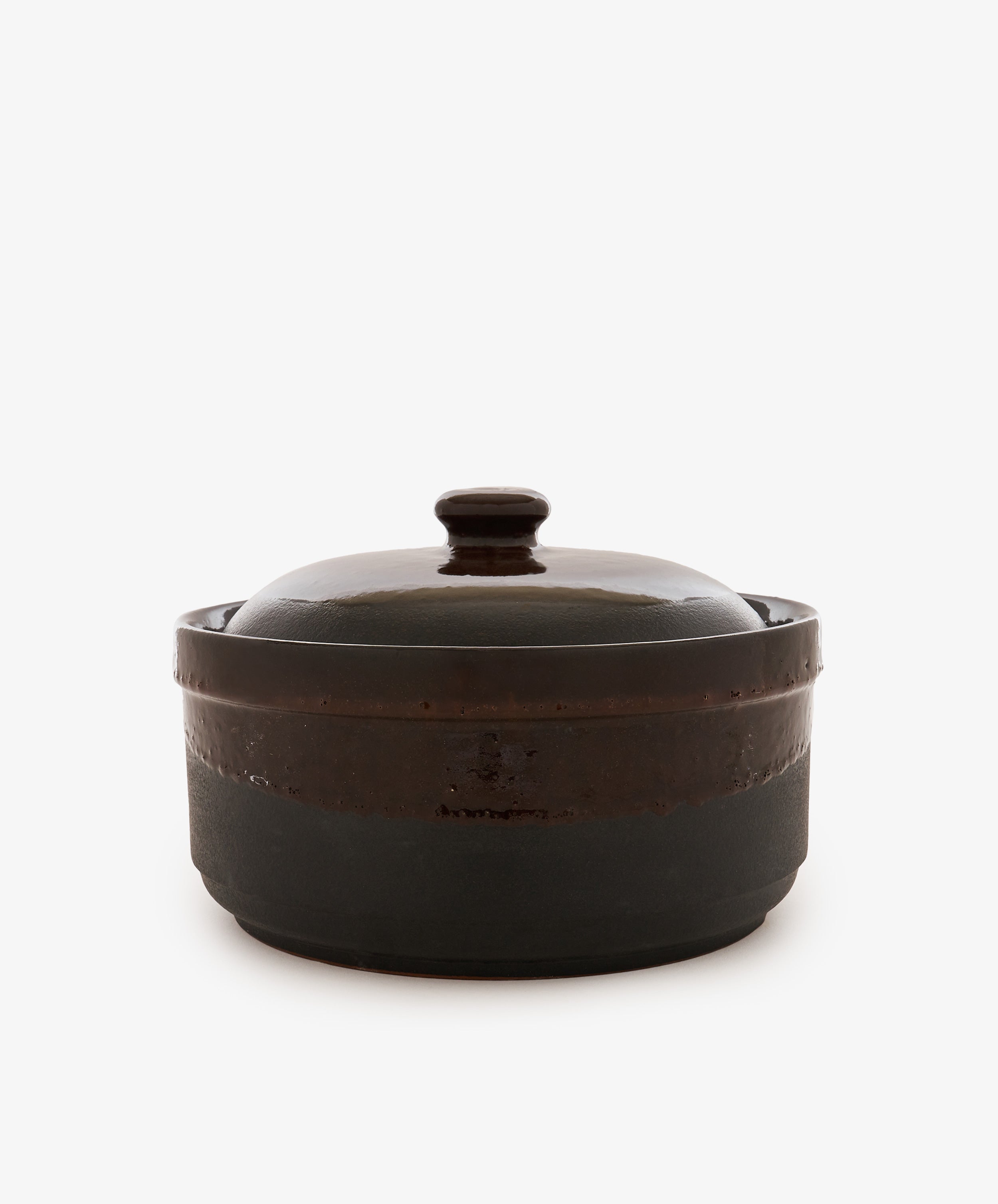 The Amany Casserole is a dark, round ceramic baking dish featuring a matching lid with a knob handle, displayed against a plain white background.