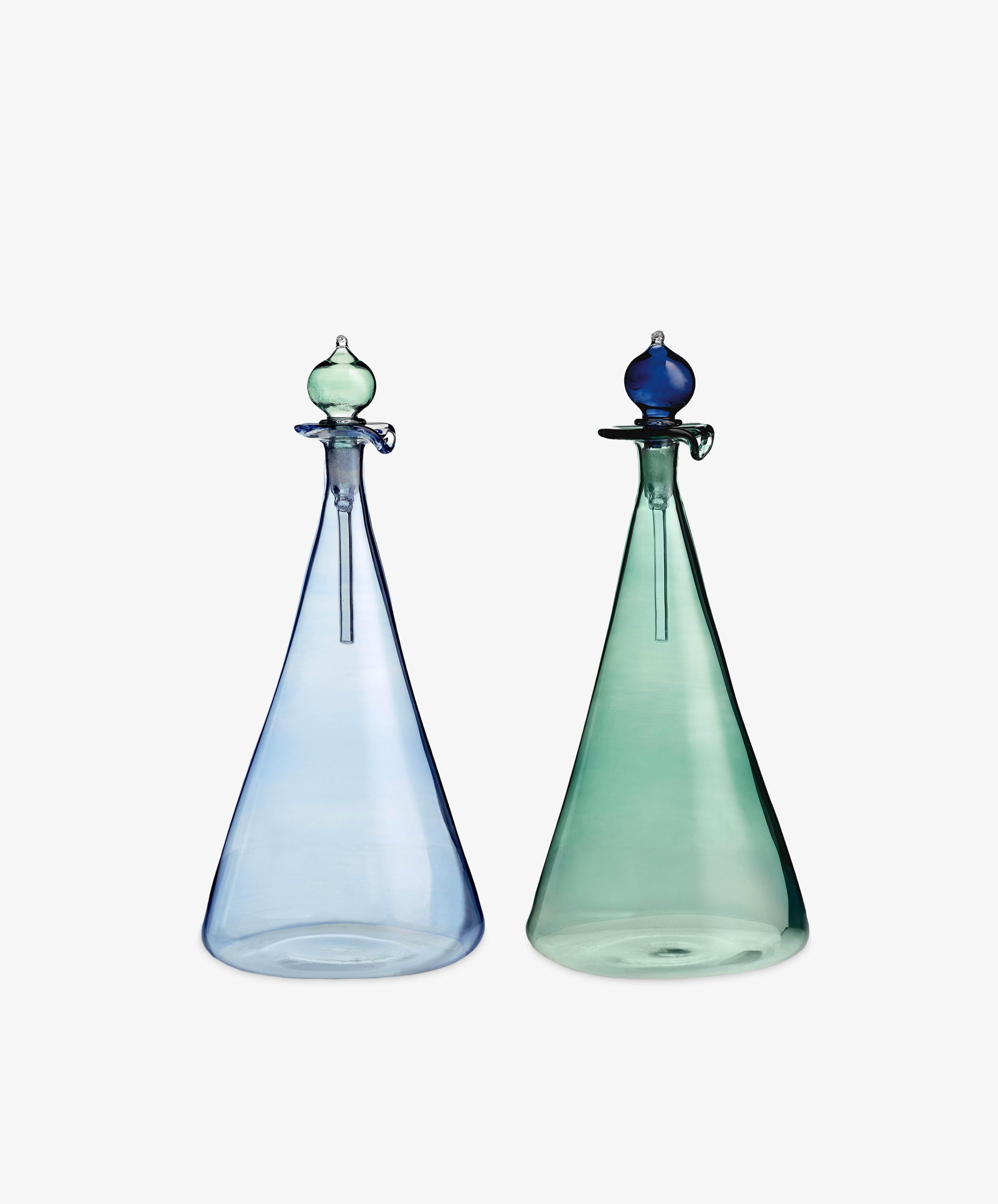 The Duo Vinegar & Oil Flask set features two tall, conical glass bottles—one light blue and one green—with stoppers, crafted in a Cairo artisan style to add an elegant, hand-blown touch to your home décor.