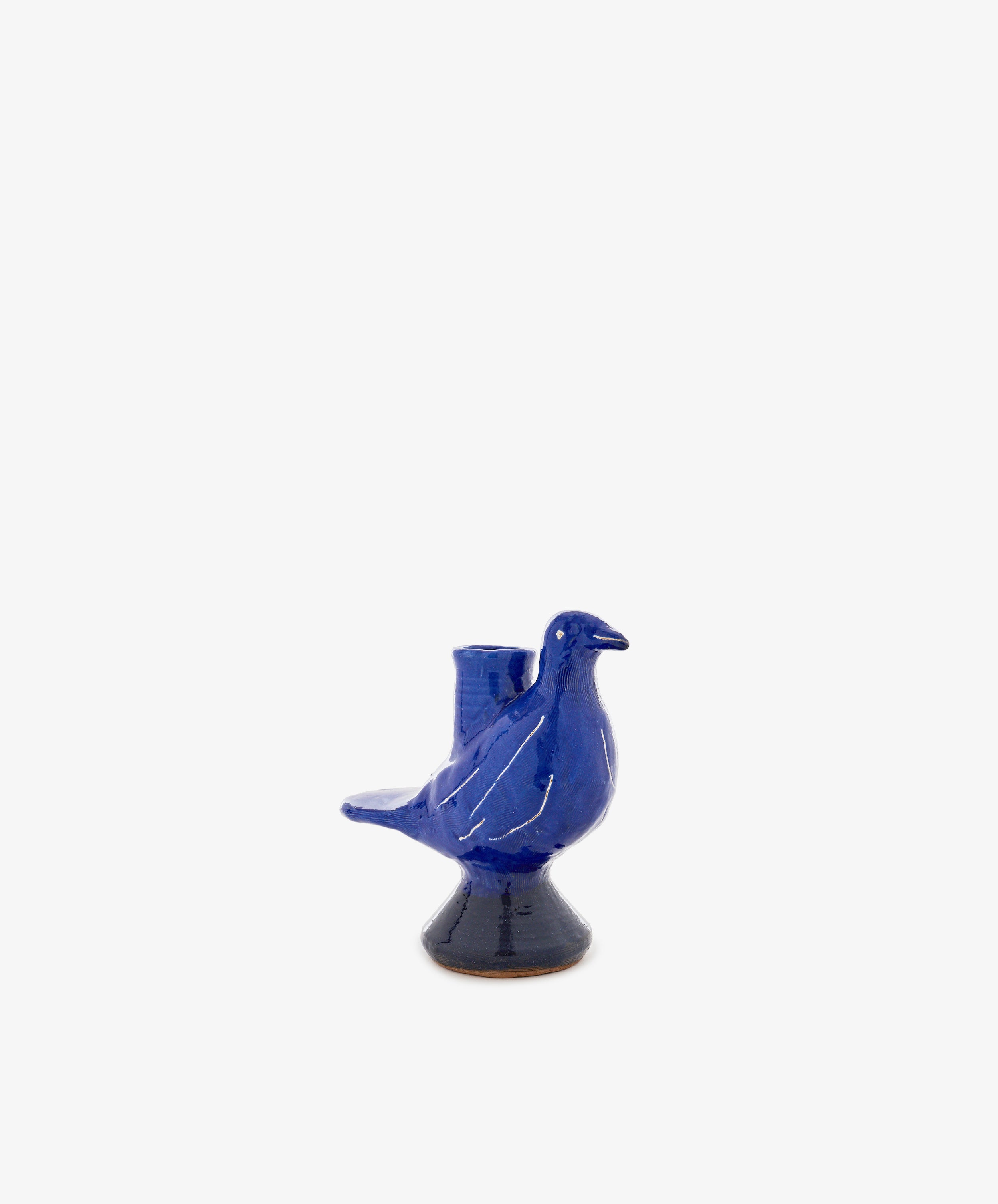 Peace Dove Candle Holder crafted from blue ceramic in the shape of a bird, finished with a rich cobalt glaze and featuring a small opening on its back, set against a plain white background.