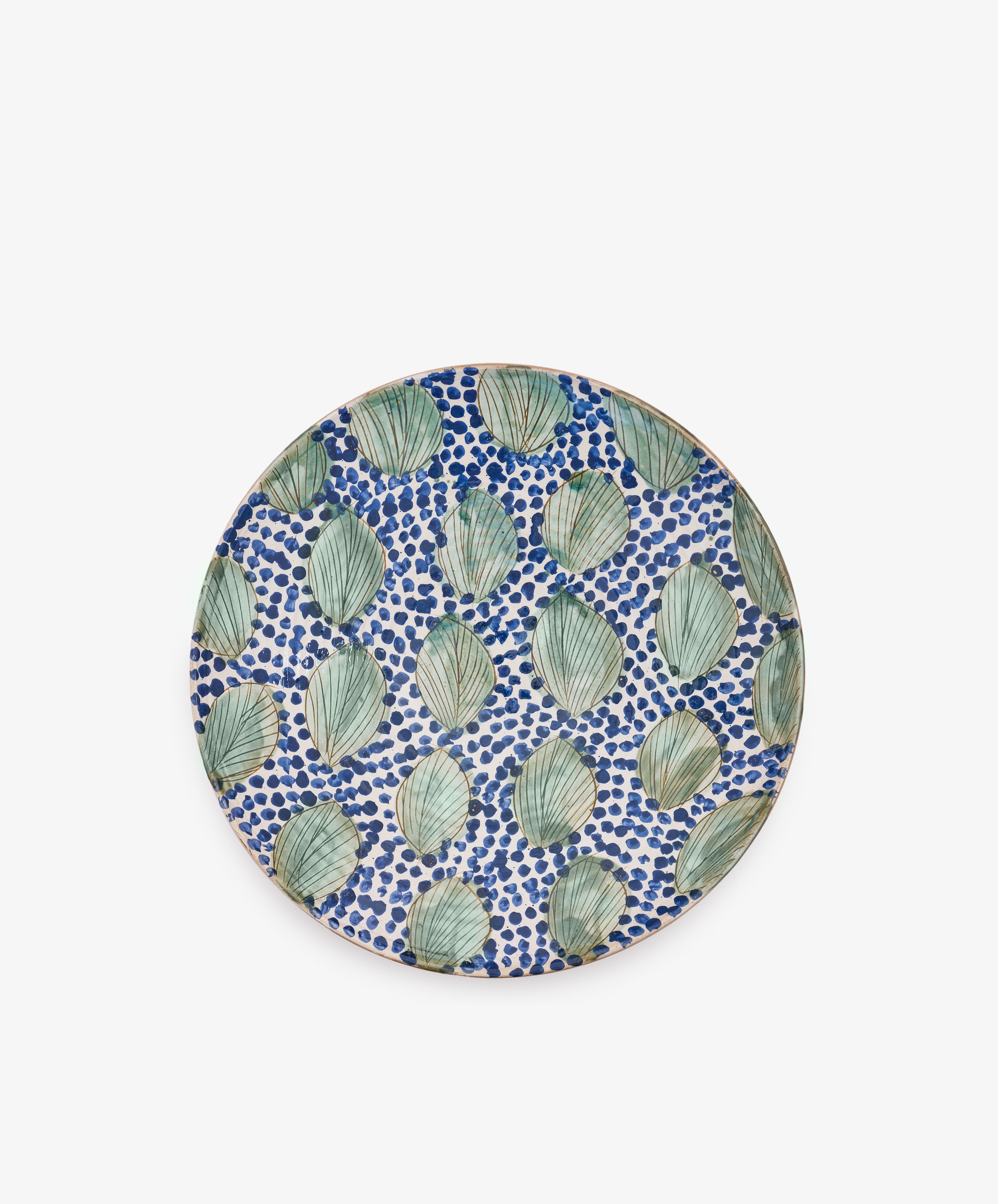 Green Leaves Serving Bowl inspired by Fayoum pottery, featuring a pattern of green leaves and blue dots on a white background, viewed from above against a plain white surface.